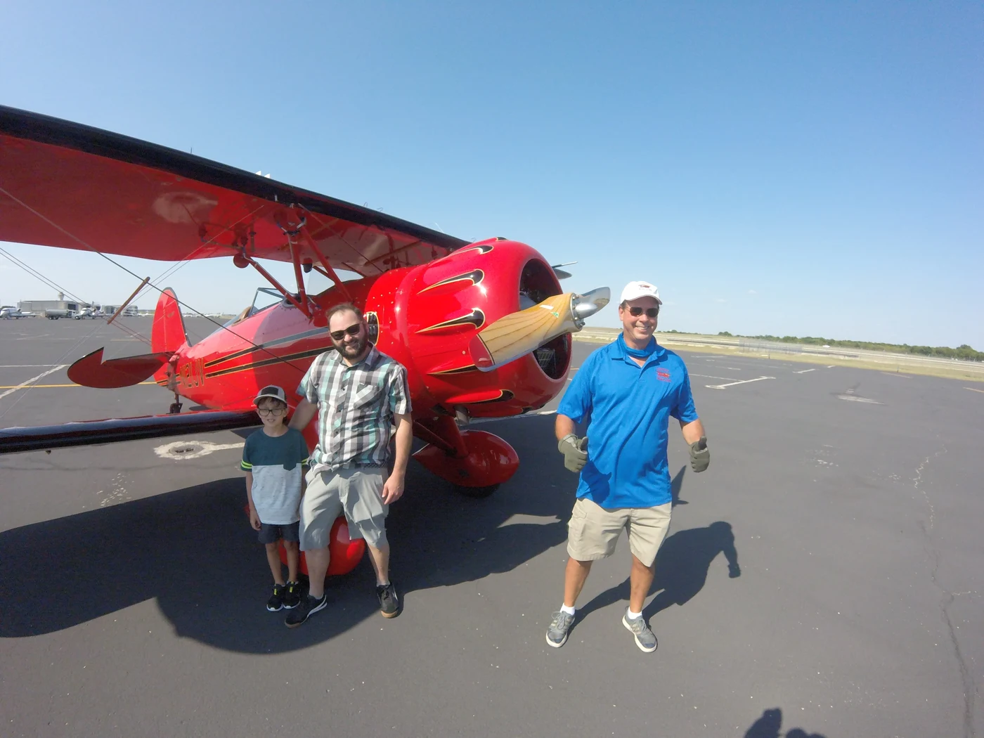 Dads beside a red biplane on a Dad Tribes experience