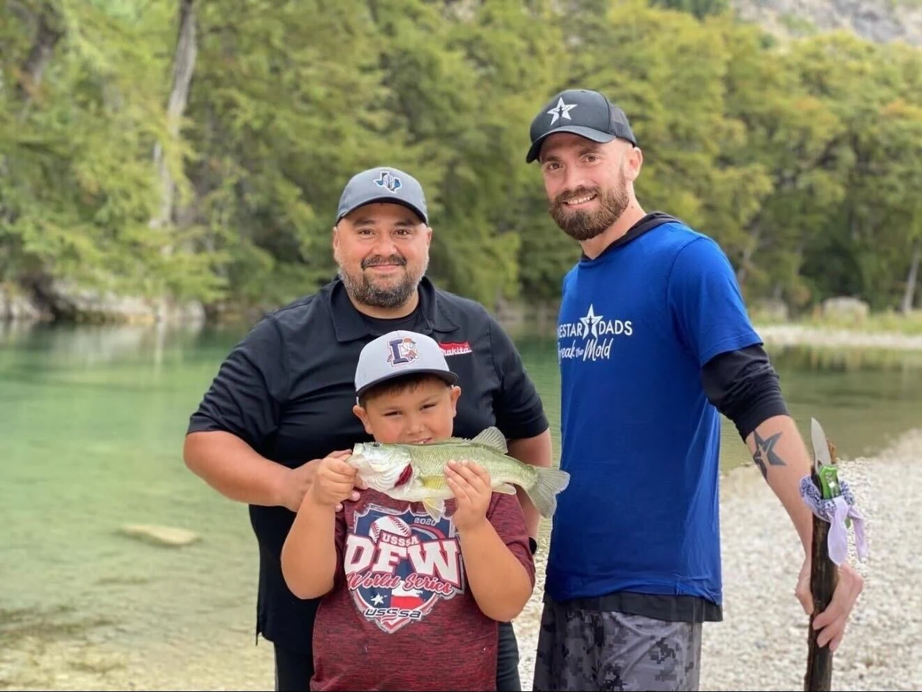 Dads and a child smiling together at a community gathering